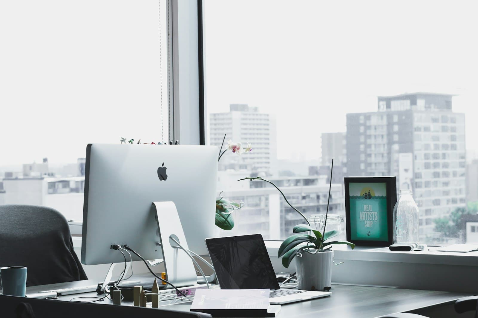 A quiet office desk with a monitor and a city view, the kind of small MSP that adds security advisory without a dedicated hire